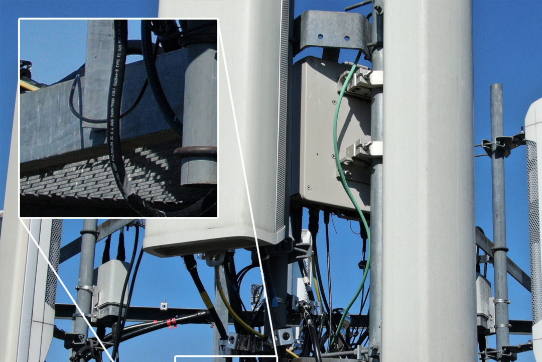 Close-up view of top of cell tower with zoomed inset showing wire markings